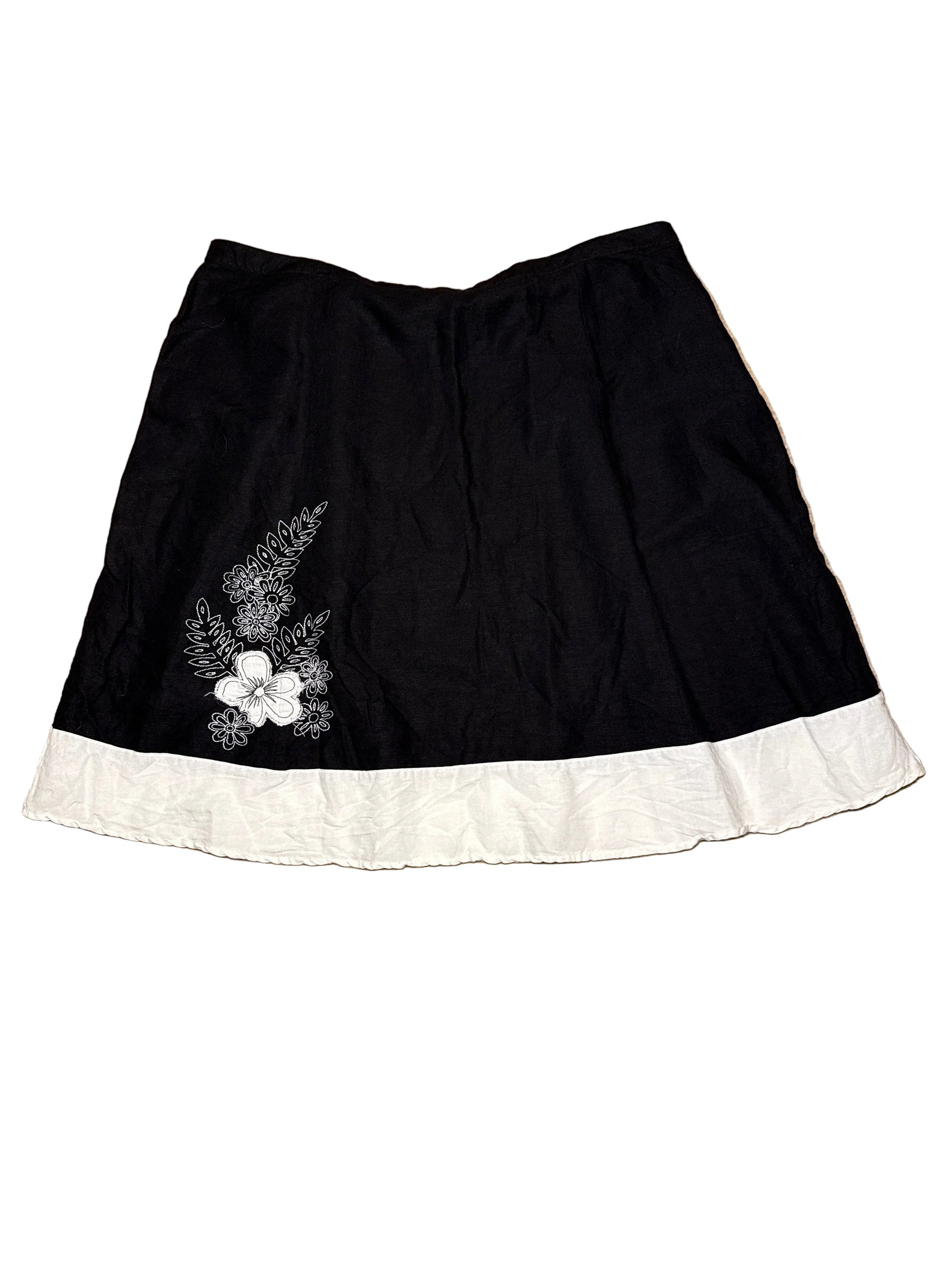 Black skirt with white floral embroidery on a white background