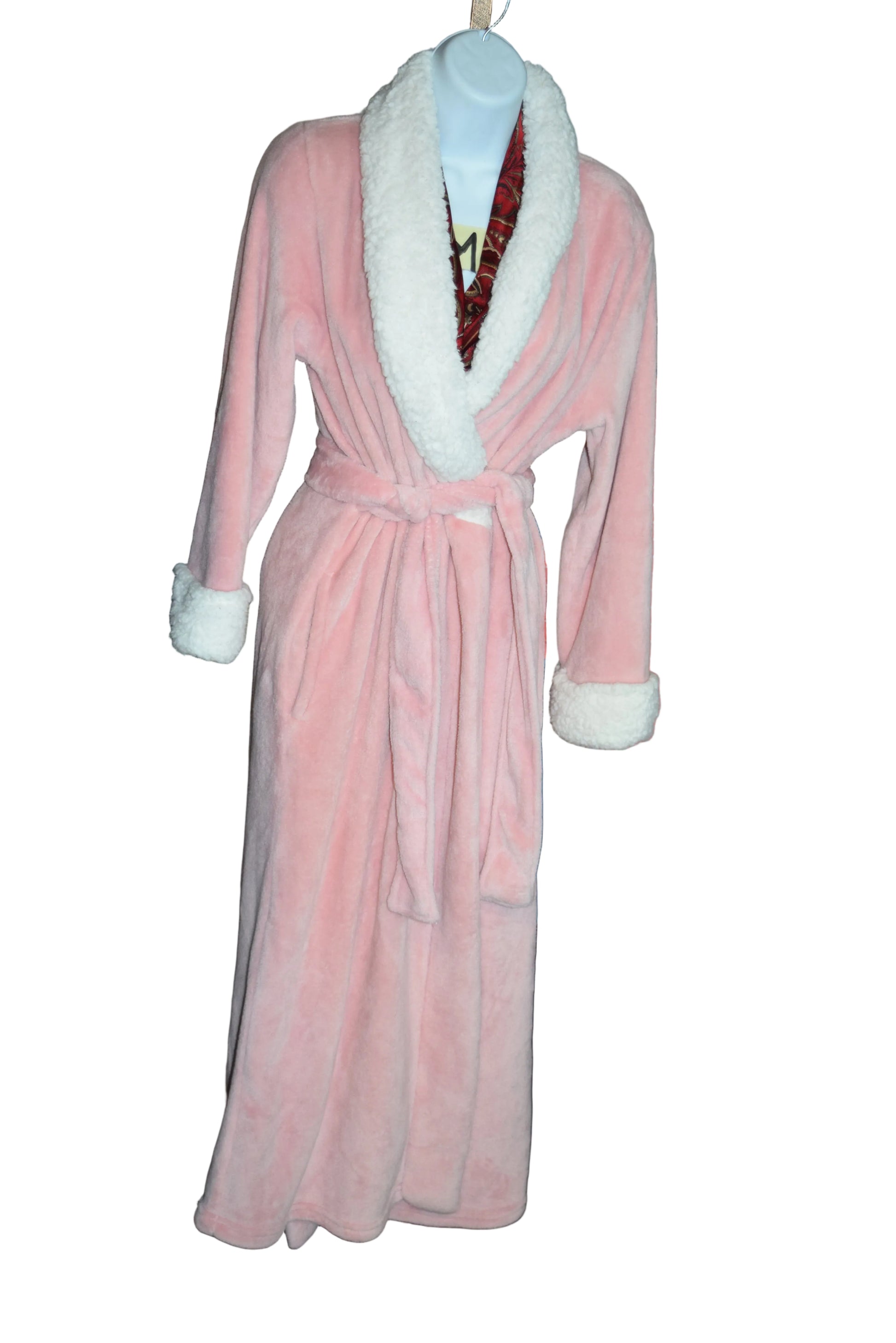 Pink dress with white trim on a rack with other clothing items in the background.