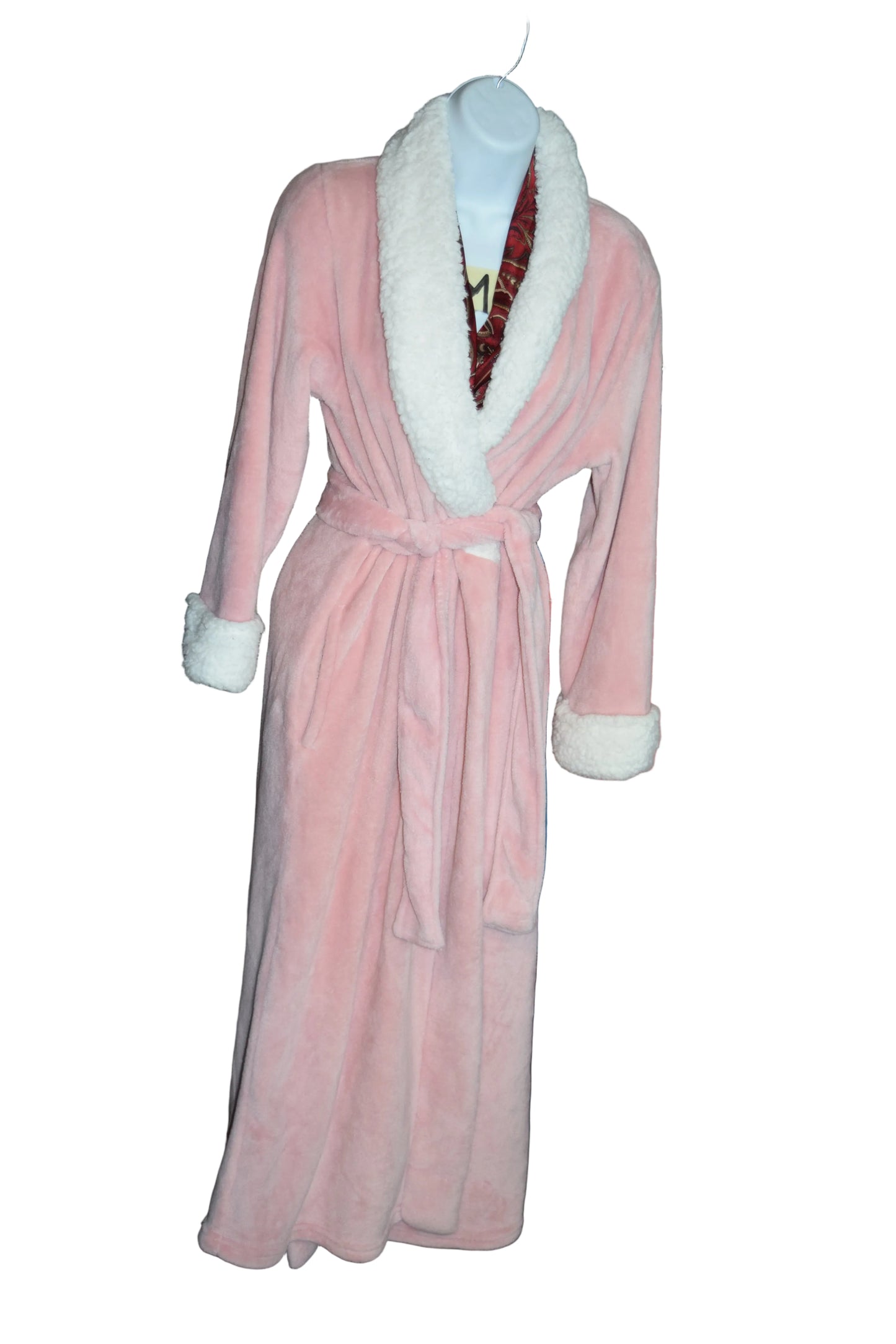 Pink robe with white trim on a mannequin in front of folded clothes.