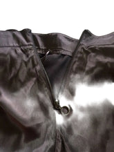 Load image into Gallery viewer, Close-up of a brown jacket with a zipper on a textured surface

